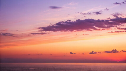 Fototapeta premium Serene sunset over the ocean, painting the sky with vibrant hues of orange, pink, and purple, a breathtaking spectacle of nature's artistry.