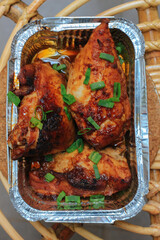Homemade baked chicken breast in the aluminum foil box served on the table barbeque grill....
