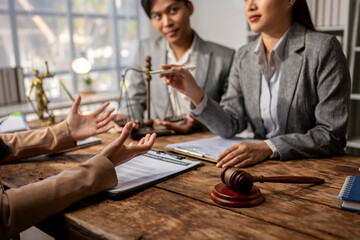 Three people are sitting at a table in a courtroom