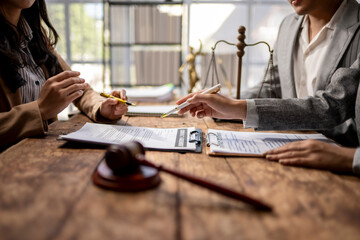Two people are sitting at a table with papers and a gavel