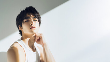 ランニングを着た若い男性は考え事をしている