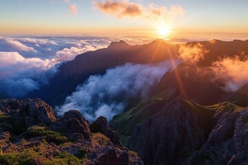 Sunrise over misty mountains with clouds and vibrant colors.