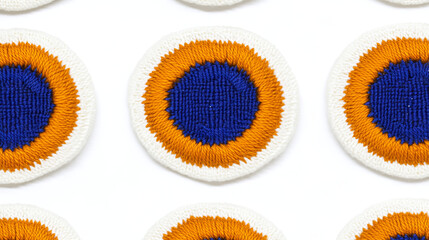 Fototapeta premium Circular embroidered patches with blue centers and orange borders on white background. pattern is repetitive and evenly spaced, creating visually appealing design