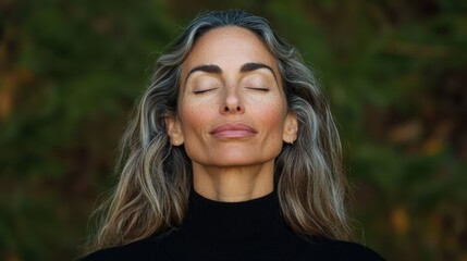 Fototapeta premium Woman with long, wavy gray hair in a black turtleneck sweater in a serene outdoor setting