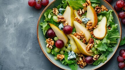 Fresh pear and blue cheese salad with mixed greens, walnuts, and grapes