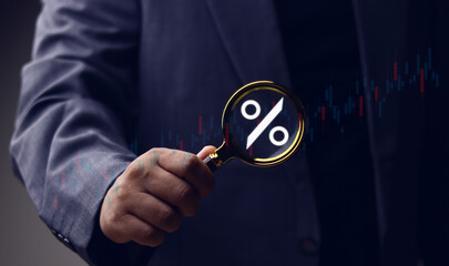 Financial market volatility, interest rates, economic trends, financial interest rate concept and market trends, businessman holding magnifying glass with percentage symbol.
