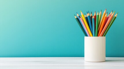 Colorful Pencils in a White Holder Against a Teal Background