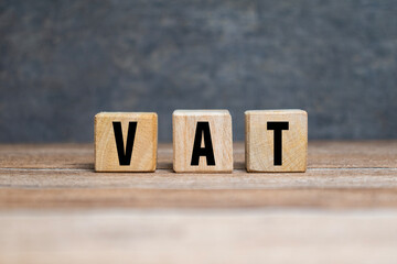 vat letter symbol or value added tax on wooden blocks isolated on blue background