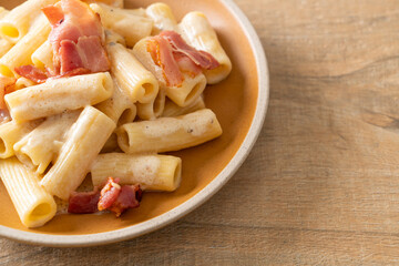 spaghetti rigatoni pasta with white sauce and bacon