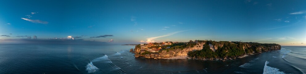 Obraz premium Panorama of Uluwatu Point in Bali Bathed in Golden sunlight from a sunset. Taken from a drone in February 2025