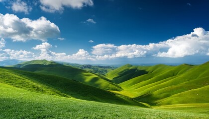 Obraz premium rolling green hills under a blue sky with white clouds
