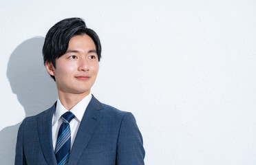 遠くを見つめるスーツを着た男性の横顔