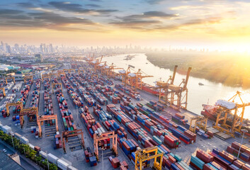 Aerial view and top view cargo Logistics and transportation of Container Cargo ship and Cargo plane with working crane bridge in shipyard at sunrise, logistic import export and transport 