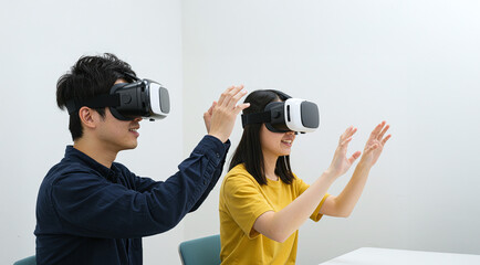 Fototapeta premium 仮想現実ヘッドセットを使用する若い男女（アジア人）