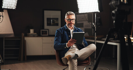 Live stream host, recording and man with tablet in home studio for talk show, online interview or...