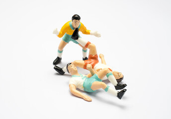 A soccer player toy is playing football.