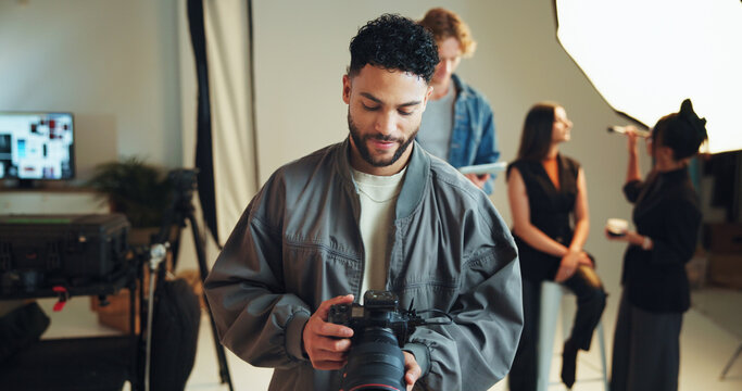 Camera, photography and review with man in studio for start of professional magazine photoshoot. Backstage, media or results with makeup artist, model and photographer getting ready on film set - Powered by Adobe