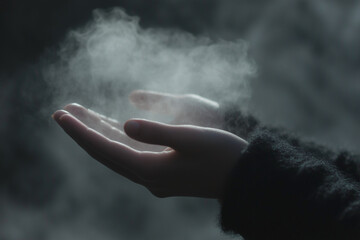 hand is holding a cigarette and the smoke is rising. Scene is one of contemplation or reflection, as the person is holding the cigarette and the smoke is rising