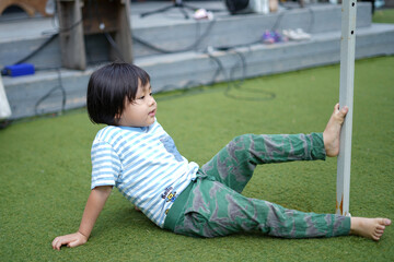 Fototapeta premium 足で棒を掴む男の子/Boy holding a stick with his foot