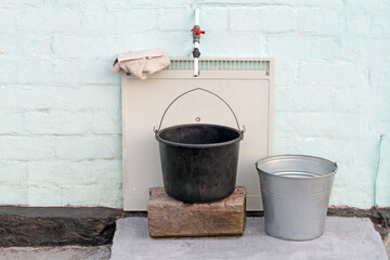 Outdoor tap with buckets for water. Outdoor water buckets.
