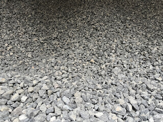 Top view of granite stones outdoor. Crushed fraction granite background. Textured gray stone for background.