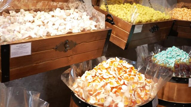 Lots of colorful marmalade and sweets of different shapes and sizes in the candy store close up. Confectionery. Pile of multi-colored marmalade are on the counter of bazaar.