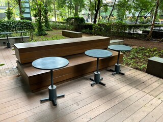 Outdoor bench in a green public open space environment, placed in city centre 