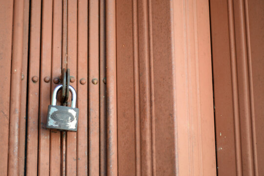 a padlock that locks an iron door - Powered by Adobe