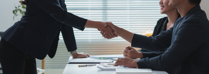 Businesspeople shaking hands after successful meeting in office