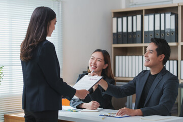 Applicant giving resume to hr managers in office for job interview