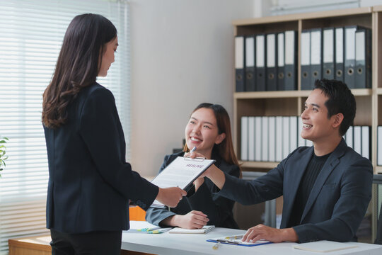 Applicant giving resume to hr managers in office for job interview