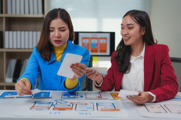 Ux designers discussing mobile application wireframes in office meeting