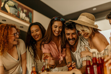 Group of diverse friends laughing and drinking beverages at a party