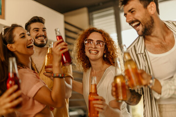 Happy group of diverse friends toasting drinks at a party
