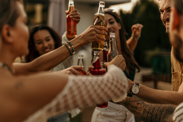 Diverse friends enjoying drinks at a pool party, celebrating and having fun