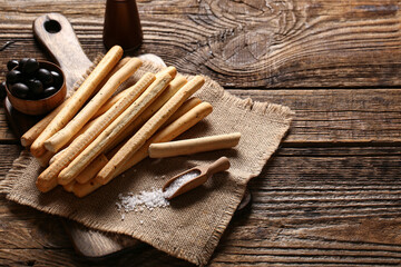 Board with tasty Italian Grissini on wooden background