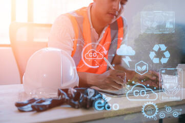 engineer working on digital tablet project planning to reduce CO2 emissions carbon footprint...