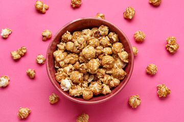 Bowl with tasty popcorn on pink background