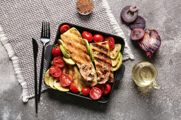 Baking dish with tasty grilled vegetables on grunge background