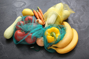 Eco bags with different fresh vegetables on black background