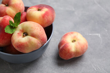 Bowl with sweet fig peaches and mint on grey background