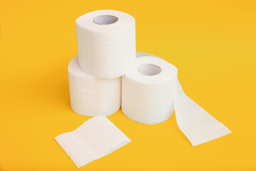 Rolls of toilet paper on yellow background