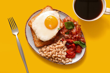 Plate with tasty English breakfast and cup of coffee on yellow background