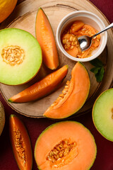 Wooden boards with tasty ripe melons on red background © Pixel-Shot