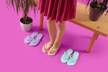 Young woman and different flip-flops on magenta background