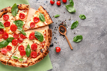 Wooden board of tasty pizza Margarita with fresh tomatoes on grey background