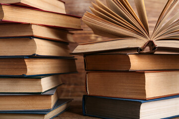 Stacks of old hardcover books on wooden background, closeup