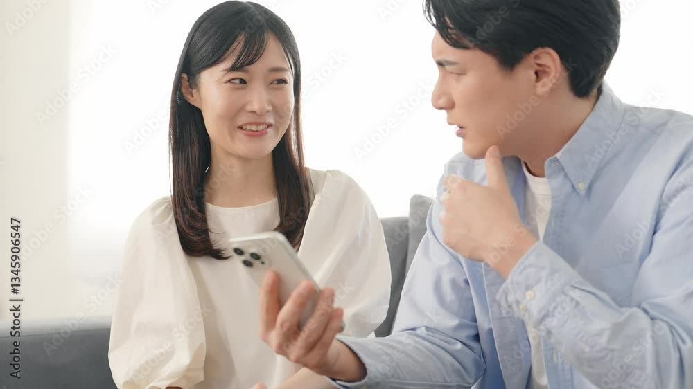 Leinwandbilder スマホ、スマートフォン、カップル、夫婦、トラブル、苦笑い、相談、失敗、リスク、残念、困る、詐欺、フェイクニュース、アプリ、SNS、炎上、スキャンダル、ニュース、動画、口論、疑問、不安、心配、不満、男性、女性、日本人、リビングルーム、ソーシャルメディア、注意、指摘、文句、会話、災害、事件、事故、呆れる、ライフスタイル、共感、悩む、悩み、おしゃべり、インターネット、オンライン、web、配信、表情、メー