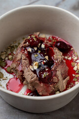 Delightful chocolate mousse rests in a minimalist bowl, adorned with vibrant berry compote and scattered with crunchy nuts, showcasing exquisite European culinary elegance