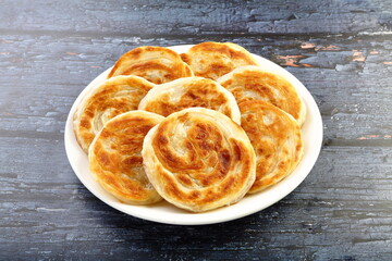 Healthy wheat parthas served in white ceramic plate.